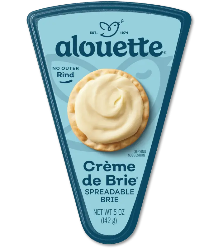 Alouette Crème de Brie spreadable cheese package showing a cracker with creamy brie spread on top, 5 oz net weight.