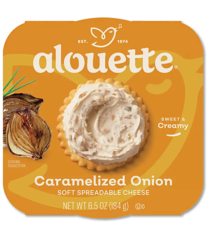 Alouette Caramelized Onion soft spreadable cheese package with a scoop of creamy spread and whole onion on orange background.