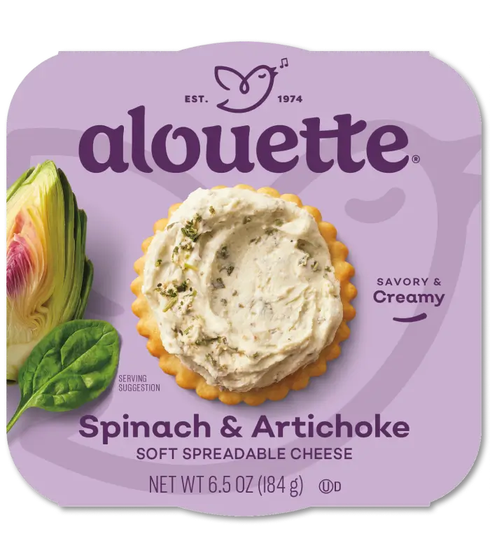 Alouette spinach and artichoke soft spreadable cheese package with a cracker topped with the creamy spread, fresh spinach leaf, and product details visible.